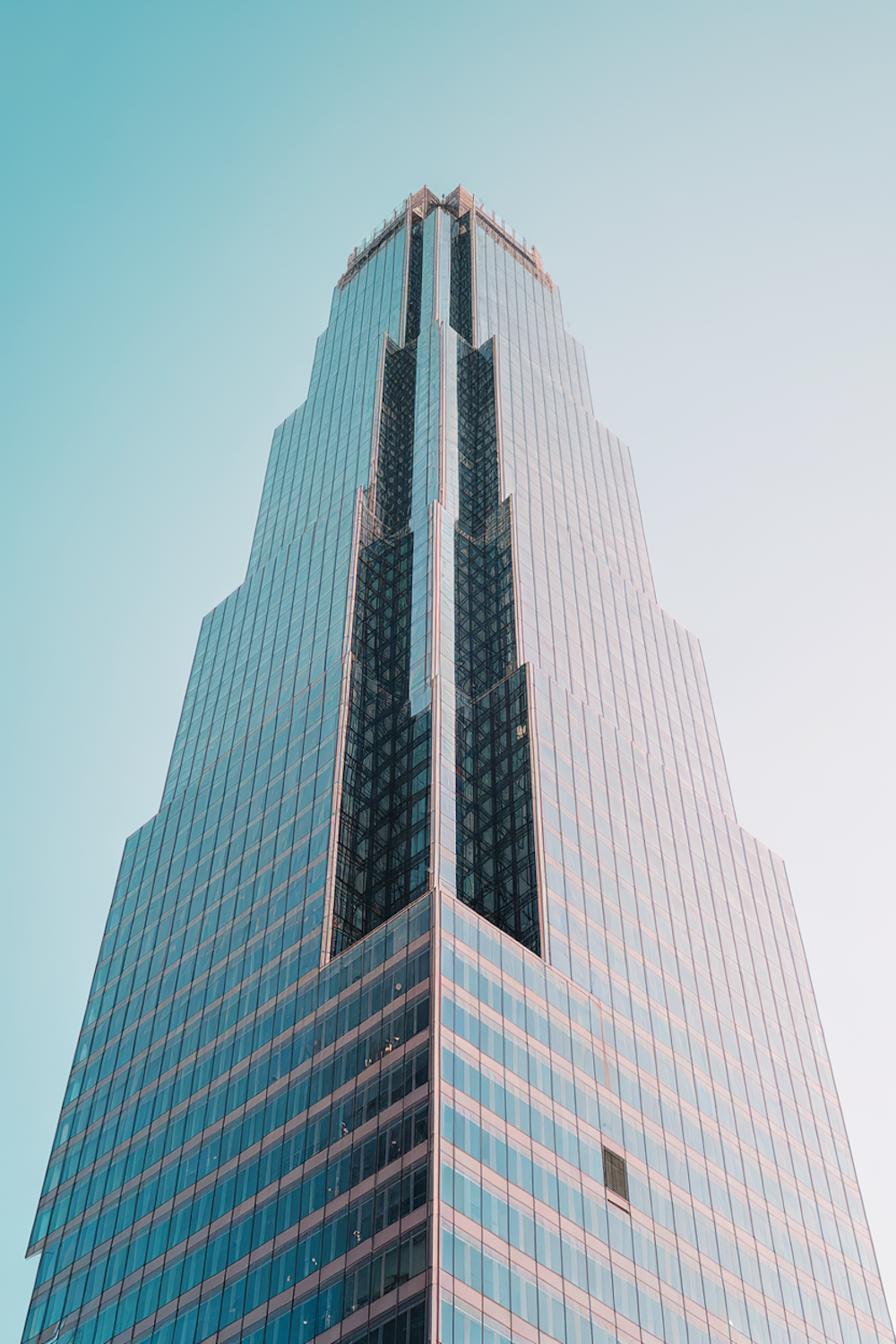 Glass curtain wall tower rising against a clear sky